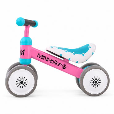 Pink mini toddler balance bike side view with aqua handlebars, padded seat and 4 grey wheels