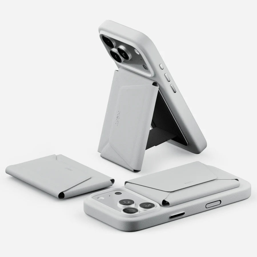 A light gray phone case with a built-in folding stand and card slots, shown in multiple angles on a clean white background. The brand name 'MOFT' is subtly embossed on the stand.