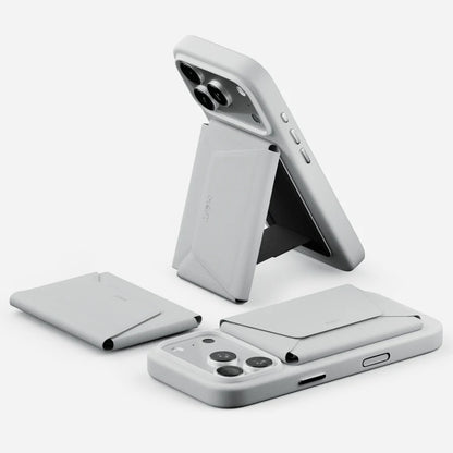 A light gray phone case with a built-in folding stand and card slots, shown in multiple angles on a clean white background. The brand name 'MOFT' is subtly embossed on the stand.