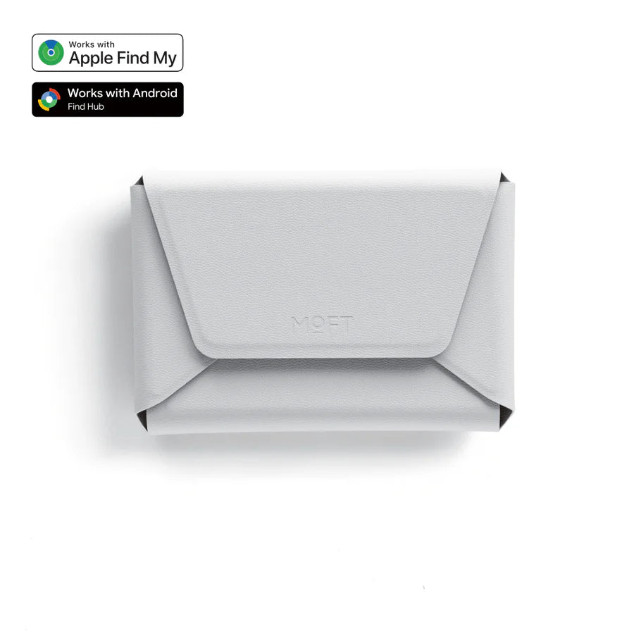 A light gray envelope-style wallet or card holder with a flap closure, shown from above on a white background. Small compatibility badges in the top-left indicate Apple Find My and Android Find Hub support.